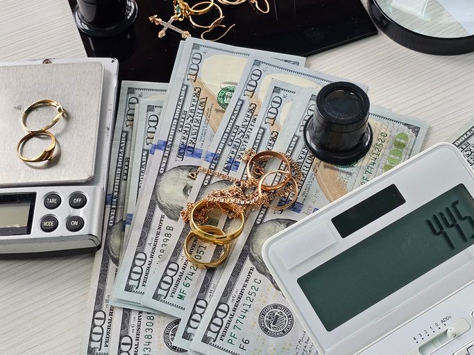 Precious gold jewelry and cash on a countertop with a digital scale in Pleasant Hill, CA